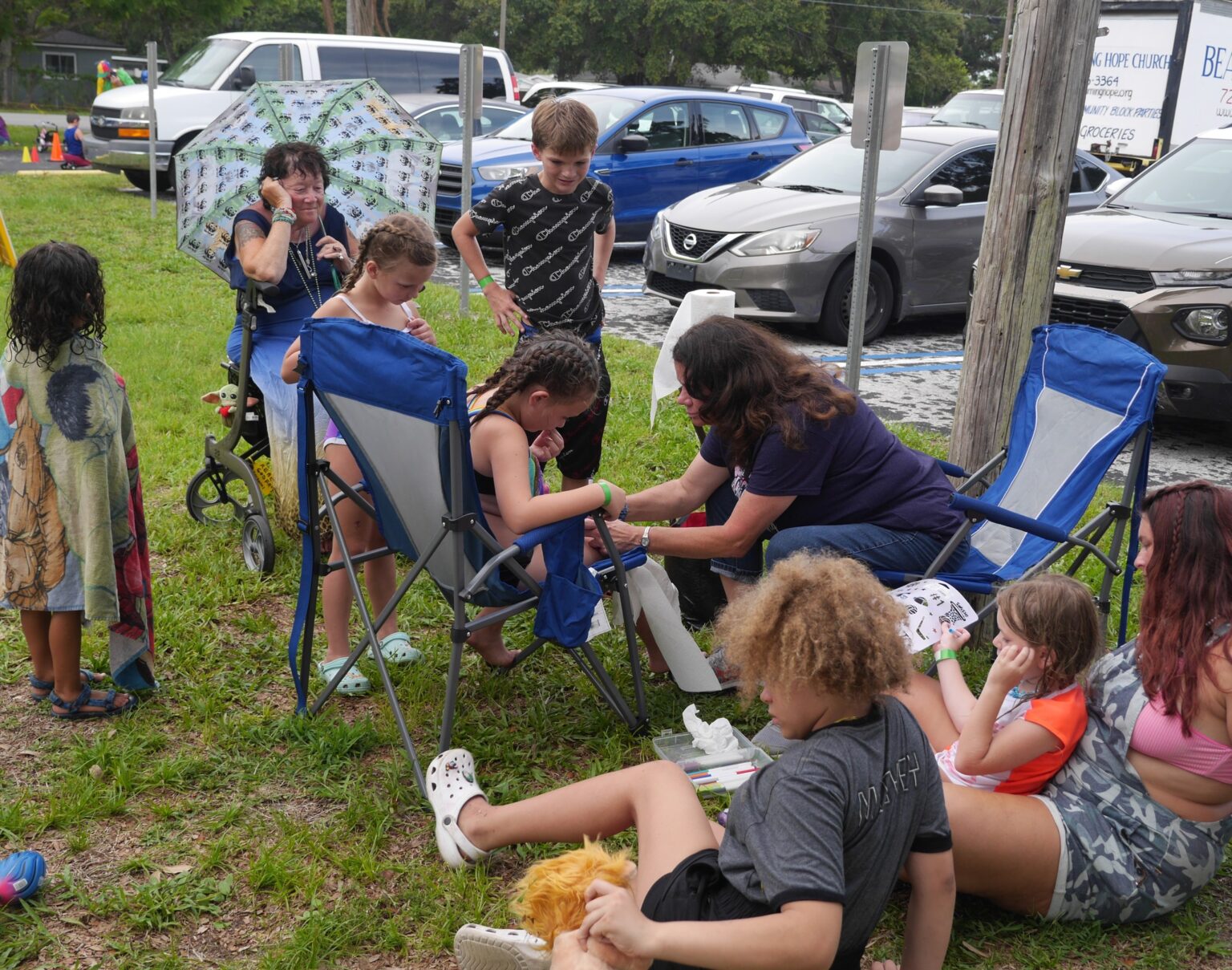 Adult helping children at outdoor gathering