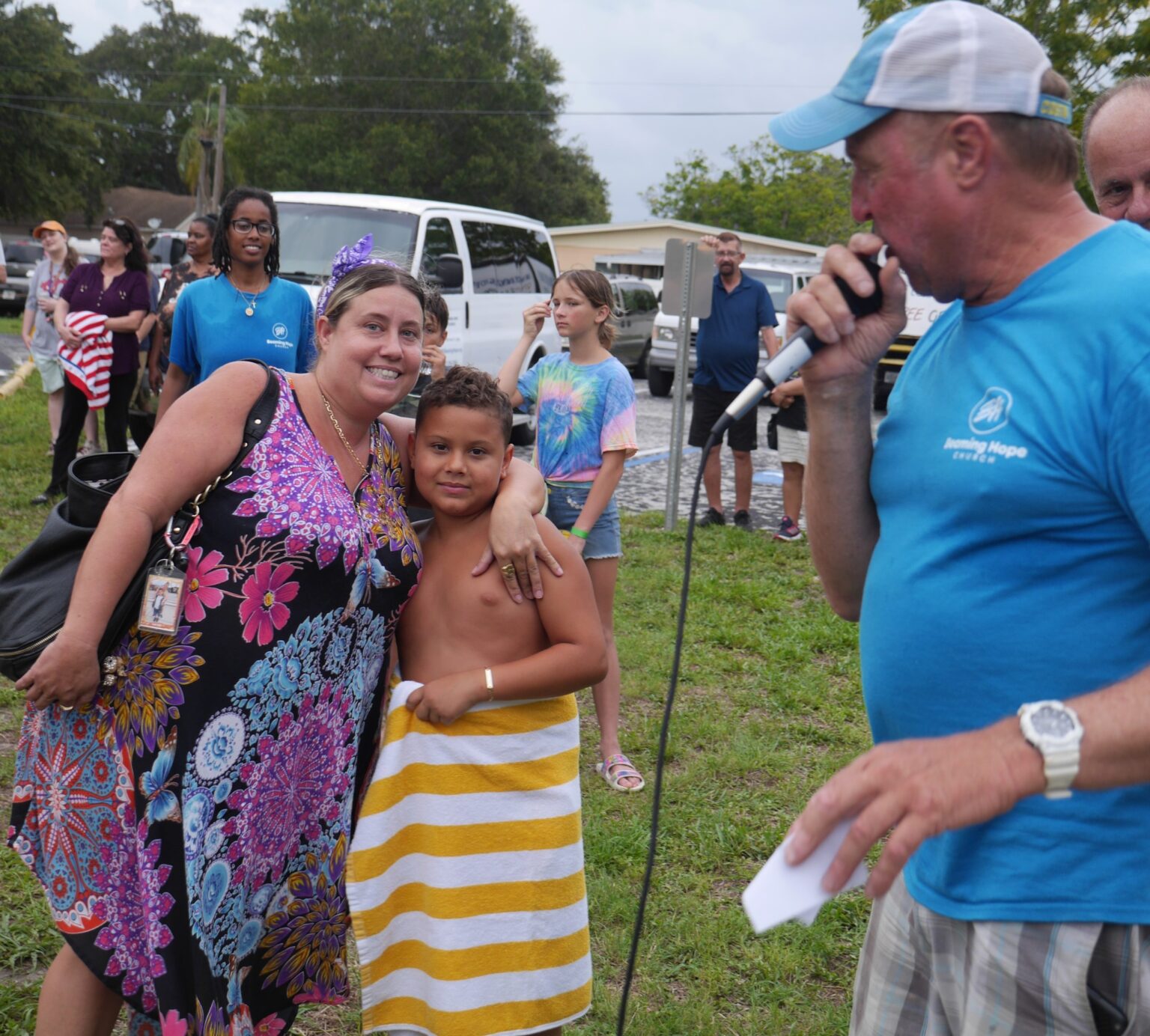 Woman and boy wrapped in towel, man speaking