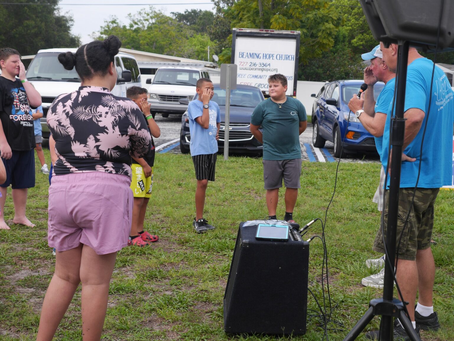 Kids and adults gathered around outdoor speaker