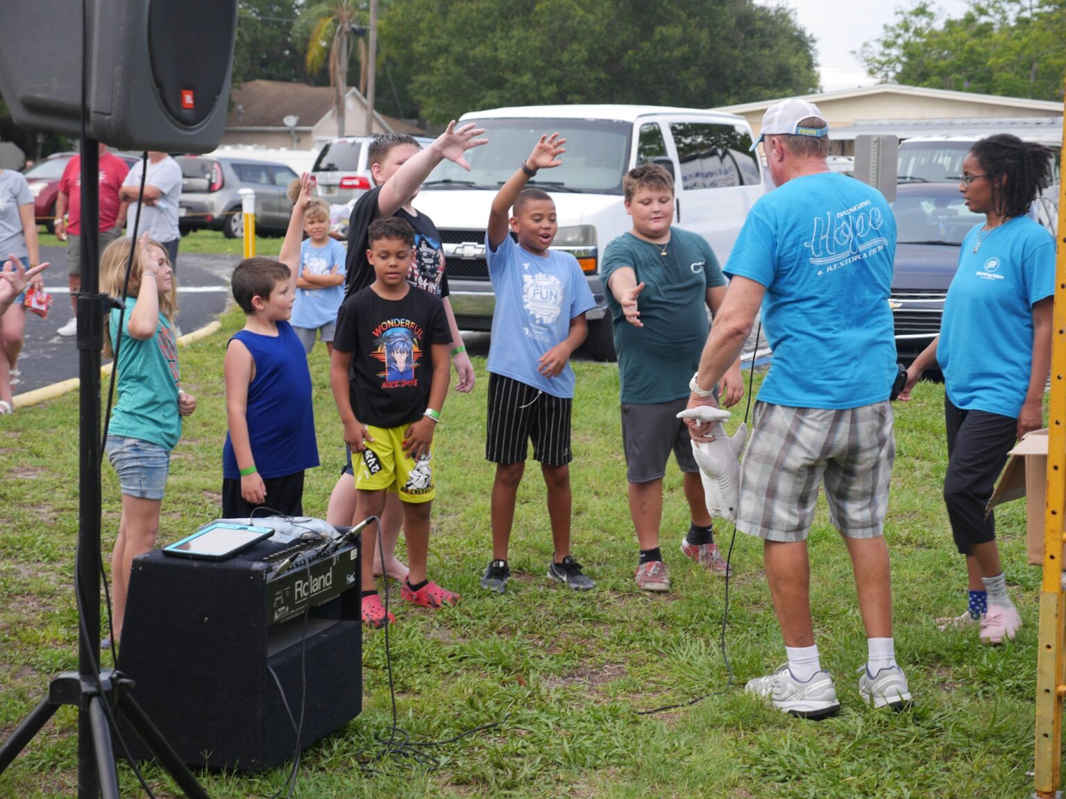 Children in outdoor group activity with adults